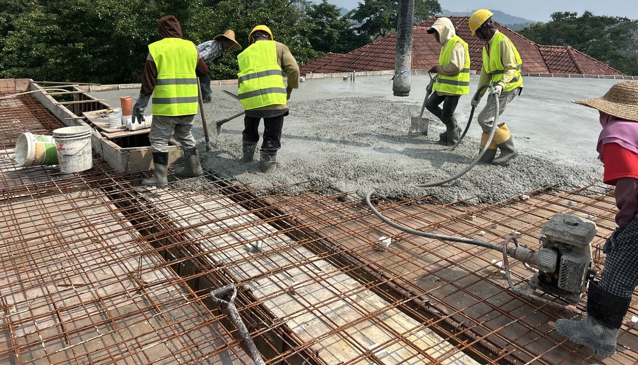 Construction crew placing concrete on a reinforced slab