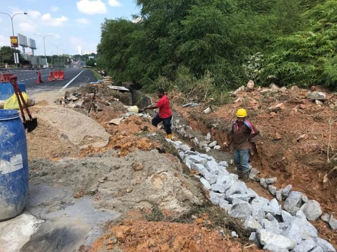 Rock-lined channel and slope protection being placed by workers